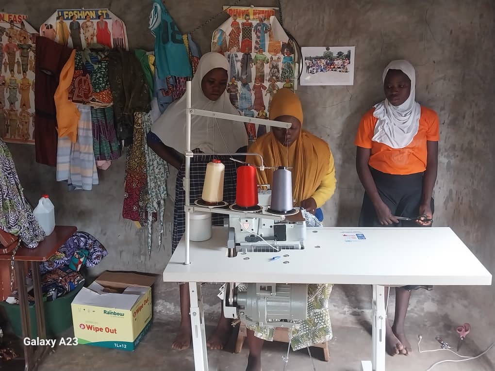 Women operating a knitting machine in a tailoring shop